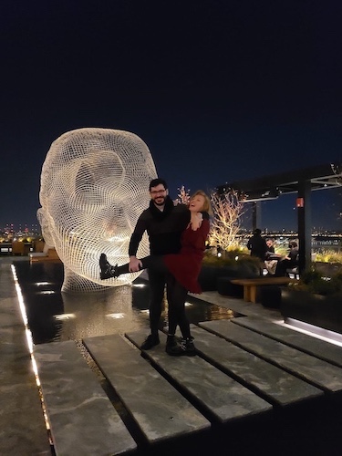 Nina and Chris being silly at some rooftop restaurant.